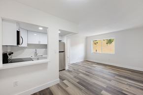 Miami apartment for rent - A kitchen with white cabinets and a wooden floor.