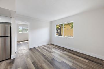 Miami apartment for rent - A kitchen with a refrigerator and a window with a view of trees.