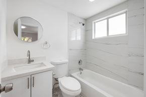 Miami apartment for rent - A white bathroom with a toilet, sink, and bathtub.