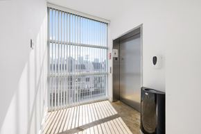 Miami apartment for rent - A modern room with a glass door leading to a balcony.