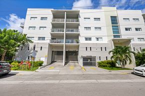 Miami apartment for rent - A white building with a balcony on the second floor.
