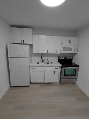 Miami apartment for rent - A kitchen with white appliances and cabinets.