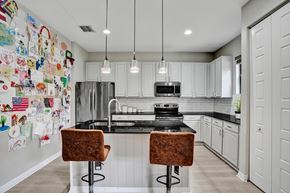 Miami apartment for rent - A kitchen with a black counter top and white cabinets.