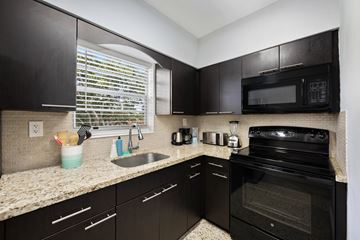 Miami apartment for rent - A kitchen with black cabinets and appliances.