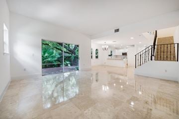 Miami townhouse for rent - A spacious room with marble flooring and a staircase on the right side.