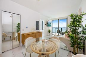 Miami apartment for rent - A modern dining room with a glass table and chairs.
