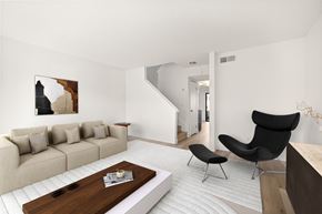 El Cajon apartment for rent - A living room with a beige sofa, a black chair, and a wooden coffee table.