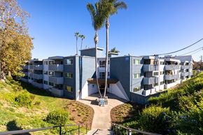 San Diego apartment for rent - A modern apartment complex with a palm tree in front.