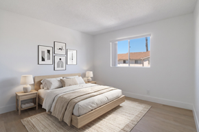 Ramona apartment for rent - A bedroom with a large bed and a window overlooking a building.