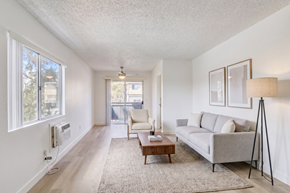Lakeside apartment for rent - A living room with a grey couch, a coffee table, and a lamp.