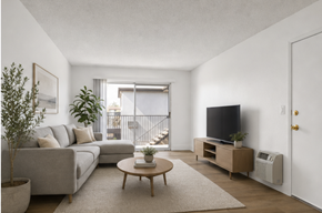 El Cajon apartment for rent - A living room with a grey couch, a coffee table, a flat screen TV, and a potted plant.