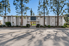 Ramona apartment for rent - A building with a white facade and a green lawn in front.