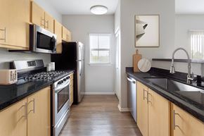 Modesto apartment for rent - A kitchen with wooden cabinets and black countertops.