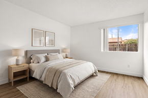 Ramona apartment for rent - A bedroom with a large bed and a window overlooking a fence.