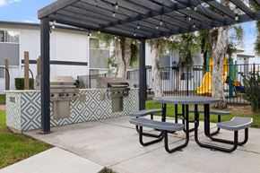 El Cajon apartment for rent - A picnic area with a grill and a table under a canopy.