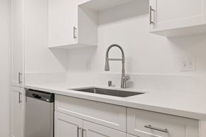El Cajon apartment for rent - A kitchen with white cabinets and a silver dishwasher.