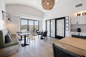 North Hollywood apartment for rent - A modern living room with a green couch and a dining table with chairs.