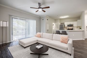 Austin apartment for rent - A modern living room with a white couch and a ceiling fan.