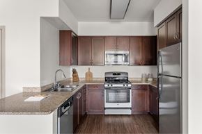 Santa Fe Springs apartment for rent - A kitchen with brown cabinets and stainless steel appliances.