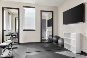 Santa Fe Springs apartment for rent - A gym with a mirror, a bench, and a ball.