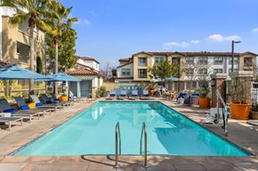Santa Fe Springs apartment for rent - A swimming pool surrounded by sun loungers and umbrellas.