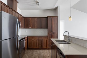 Portland apartment for rent - A kitchen with a stainless steel refrigerator and wooden cabinets.