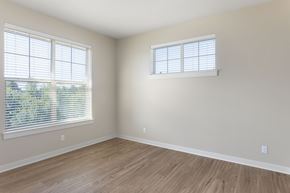Portland apartment for rent - A room with wooden flooring and two windows with blinds.