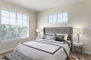 Portland apartment for rent - A bedroom with a large bed and a window with blinds.