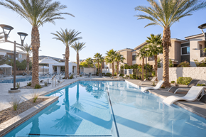 Henderson apartment for rent - A swimming pool surrounded by palm trees and lounge chairs.