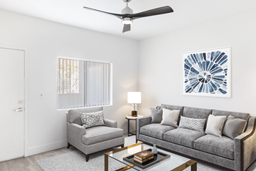 Las Vegas apartment for rent - A living room with a grey couch, a grey armchair, a coffee table, a ceiling fan, and a painting on the wall.