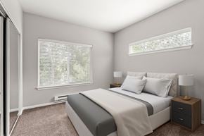 Puyallup apartment for rent - A bedroom with a large bed, a nightstand with a lamp, and a window with blinds.