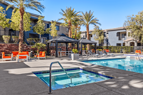 Henderson apartment for rent - A swimming pool surrounded by palm trees and lounge chairs.