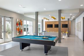 Phoenix apartment for rent - A pool table in a room with a wooden cabinet and a painting on the wall.