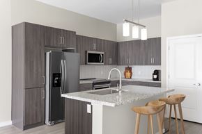 Phoenix apartment for rent - A kitchen with a refrigerator, microwave, and stove top oven.