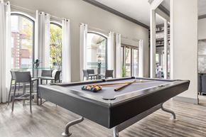 Fort Worth apartment for rent - A pool table is in the middle of a room with a lot of windows.