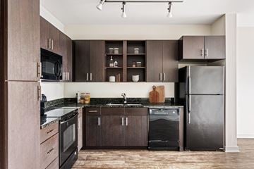 Nashville apartment for rent - A kitchen with dark wood cabinets and black appliances.