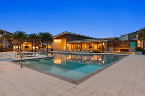 Jacksonville apartment for rent - A swimming pool in a backyard with a building in the background.