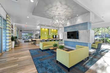 Phoenix apartment for rent - A modern living room with a yellow sofa and a blue rug.