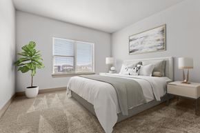 Fort Worth apartment for rent - A bedroom with a bed, nightstand, and a plant.