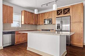 Fort Worth apartment for rent - A kitchen with wooden cabinets and a white island.