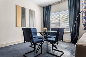 Fort Worth apartment for rent - A dining room with a glass table and blue chairs.