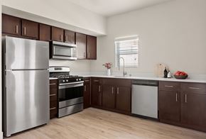 Stockton apartment for rent - A modern kitchen with dark brown cabinets and stainless steel appliances.