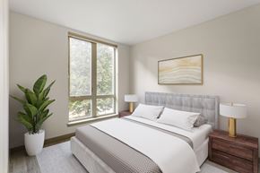 Portland apartment for rent - A bedroom with a large bed, a potted plant, and a painting on the wall.