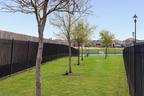 Fort Worth apartment for rent - A black fence runs along a grassy area with trees.