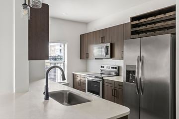 Fort Worth apartment for rent - A modern kitchen with a stainless steel refrigerator and a sink.