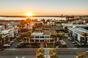 San Diego apartment for rent - A sunset view of a city street with a building that has the word