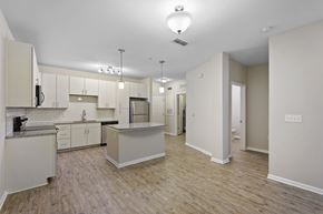 Tampa apartment for rent - A kitchen with white cabinets and a wooden floor.