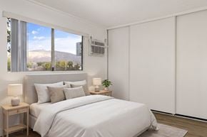 El Cajon apartment for rent - A bedroom with a large bed and a window overlooking a mountain.