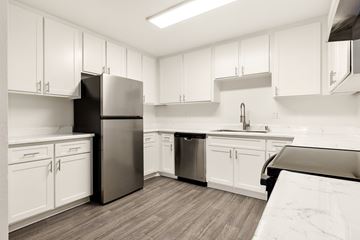 Ramona apartment for rent - A kitchen with white cabinets and a black refrigerator.
