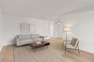 Spring Valley apartment for rent - A living room with a grey couch, a brown coffee table, and a chair with a beige cushion.